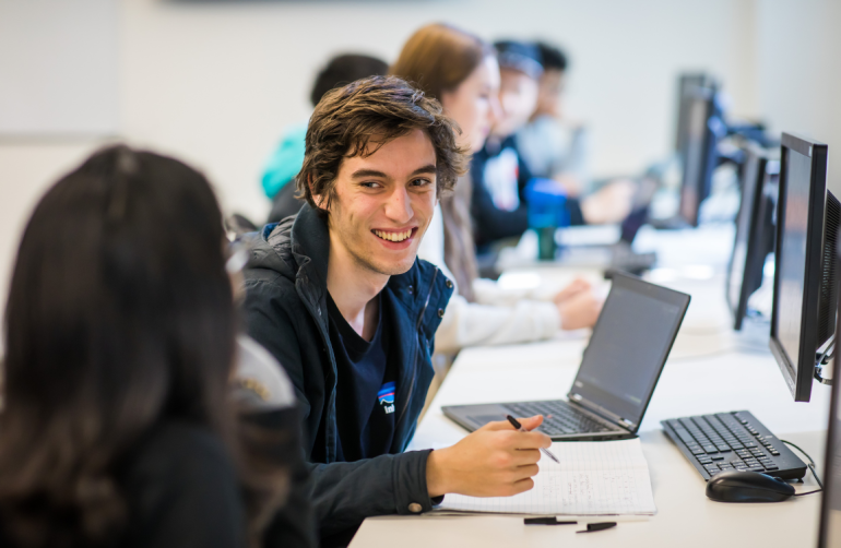 Student smiling at peer in class UNSW